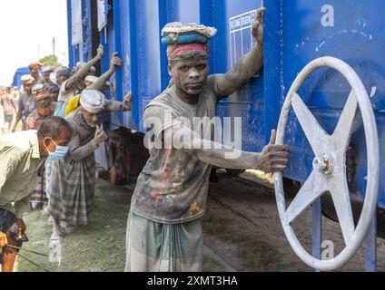 Lavoratori del Bangladesh che spingono un treno blu, divisione Khulna, Abhaynagar, Bangladesh Foto Stock