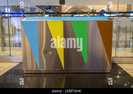 Primo piano di contenitori di rifiuti verdi, blu e rossi per lo scarico separato di vetro, carta e altri rifiuti nel punto vendita. Concetto di smaltimento corretto dei rifiuti. Foto Stock