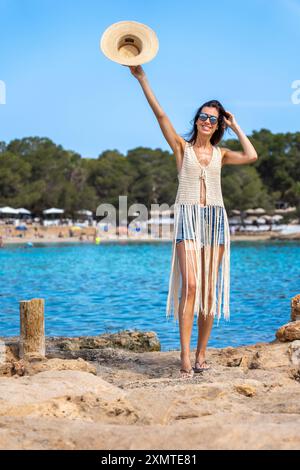 Giovane donna con camicia con frange e pantaloncini in denim al Cala bassa Ibiza Foto Stock