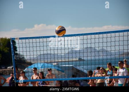 Un momento ricco di azione del torneo 3x3 di pallavolo in spiaggia di Ladeira a Baiona cattura un pallavolo che vola in aria. La scena dinamica ciao Foto Stock