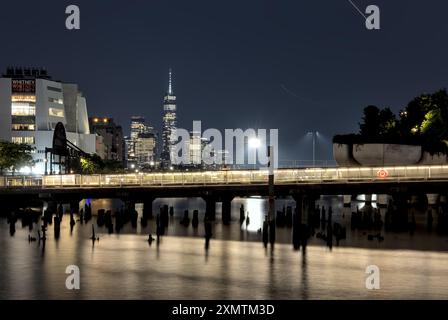 New York, NY - 9 luglio 2024: Museo Whitney con ingresso al parco sul lungomare urbano di Little Island e allo skyline del centro di New York sullo sfondo Foto Stock