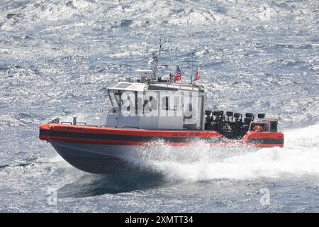 La Coast Guard Cutter Stone (WMSL 758) conduce operazioni su piccole imbarcazioni con la sua imbarcazione da taglio Interceptor a lungo raggio di 35 piedi, il 1° luglio 2024, mentre è in corso nell'Oceano Atlantico. Stone operava a sostegno della stabilità e della sicurezza marittima nella regione. (Foto della Guardia Costiera degli Stati Uniti di Alana Kickhoefer) Foto Stock