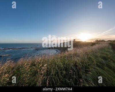 Golden Sunset Serenity: Paesaggio costiero di Kaikoura con vista sulla scogliera del mare e delle montagne, abbracciando la bellezza del sud della nuova Zelanda Foto Stock