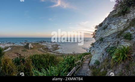 Golden Sunset Serenity: Paesaggio costiero di Kaikoura con vista sulla scogliera del mare e delle montagne, abbracciando la bellezza del sud della nuova Zelanda Foto Stock