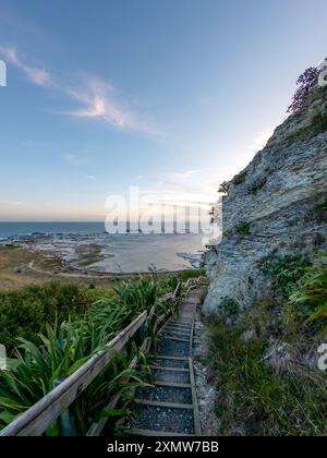 Golden Sunset Serenity: Paesaggio costiero di Kaikoura con vista sulla scogliera del mare e delle montagne, abbracciando la bellezza del sud della nuova Zelanda Foto Stock