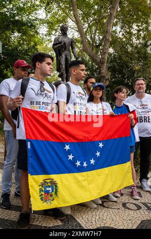 Lisbona, Portogallo. 29 luglio 2024. I manifestanti tengono capovolta la bandiera venezuelana e cantano slogan durante una dimostrazione vicino al monumento all'eroe dell'indipendenza venezuelano Simon Bolivar a Lisbona. La società civile venezuelana in Portogallo ha organizzato una manifestazione e protesta nei dintorni di Liberdade Avenue nella capitale portoghese per chiedere la revisione dei registri elettorali delle ultime elezioni venezuelane in cui è stato rieletto il presidente Nicolas Maduro Moros. Credito: SOPA Images Limited/Alamy Live News Foto Stock