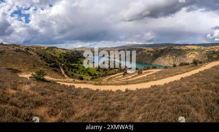 Roxburgh Cycle Trail: Spettacolare scenario di Rolling Hills, Flora nativa, e il tranquillo fiume Clutha Mataau e lago Roxburgh Hydro Dam, nuova Zelanda Foto Stock