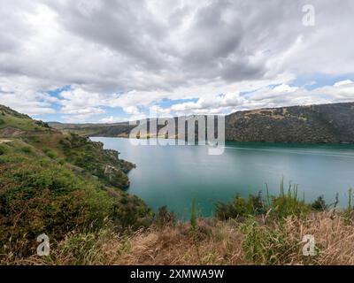 Roxburgh Cycle Trail: Spettacolare scenario di Rolling Hills, Flora nativa, e il tranquillo fiume Clutha Mataau e lago Roxburgh Hydro Dam, nuova Zelanda Foto Stock