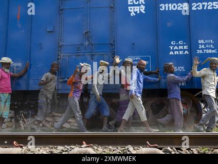 Lavoratori del Bangladesh che spingono un treno blu in linea, divisione Khulna, Abhaynagar, Bangladesh Foto Stock