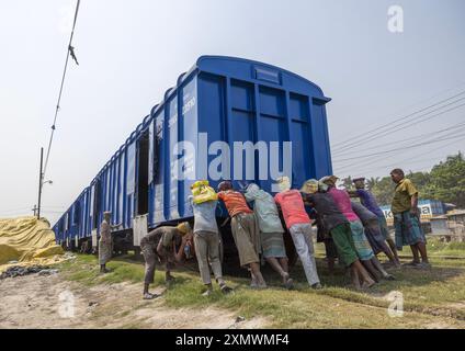 Lavoratori del Bangladesh che spingono un treno blu, divisione Khulna, Abhaynagar, Bangladesh Foto Stock