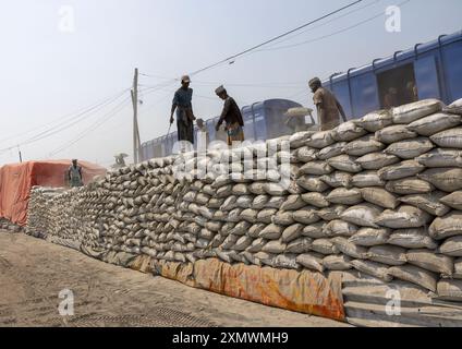 Operai del Bangladesh che scaricano sacchi di cemento da un treno, la divisione Khulna, Abhaynagar, Bangladesh Foto Stock