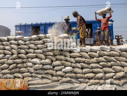 Operai del Bangladesh che scaricano sacchi di cemento da un treno, la divisione Khulna, Abhaynagar, Bangladesh Foto Stock