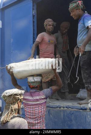 Operai del Bangladesh che scaricano sacchi di cemento da un treno, la divisione Khulna, Abhaynagar, Bangladesh Foto Stock