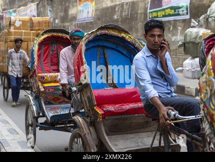 Autista di risciò al telefono nel traffico, Divisione di Dhaka, Dhaka, Bangladesh Foto Stock