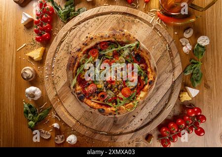 Pizza vegetariana fresca circondata da ingredienti freschi, vista dall'alto Foto Stock