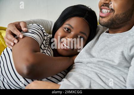 La coppia afroamericana condivide un momento tranquillo a casa, la donna riposa sulla spalla. Foto Stock