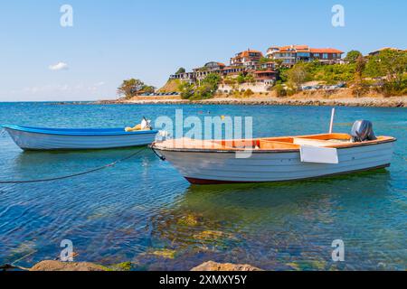 Barche ormeggiate in mare a Nessebar, Bulgaria. Paesaggio estivo soleggiato con barca ormeggiata nei boschi al molo dal cielo blu. Spiaggia pubblica. Foto Stock