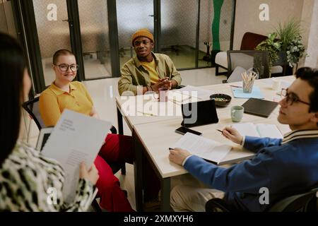 Gruppo multietnico di manager professionisti che discutono dei problemi relativi ai nuovi progetti aziendali durante la riunione in ufficio Foto Stock