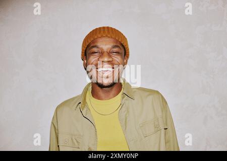 Primo piano medio ritratto di un allegro giovane afroamericano che indossa un berretto sorridente alla macchina fotografica Foto Stock