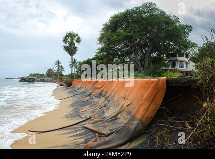 Auroville, India - luglio 2024 - Srima Beach e la guest House sono minacciate dalla crescente erosione perpetrata dall'oceano. Tessuti Geo messi per proteggere Foto Stock