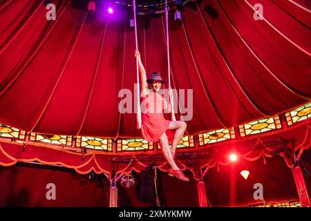 Edimburgo, Regno Unito. 30 luglio 2024 nella foto: Camille o'Sullivan seduta su un trapezio nell'iconica Spiegeltent nell'Assembly George Square Gardens. La superstar di cabaret Camille o'Sullivan festeggia 20 anni al Fringe ricreando una foto del suo primo anno di esibizione a Edimburgo nel 2004. Crediti: Rich Dyson/Alamy Live News Foto Stock