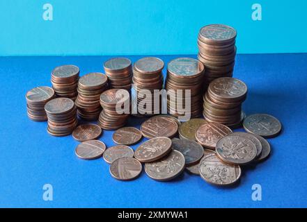 Monete inglesi basse su sfondo blu con monete da 1p, 2p incluse. Per molti anni ci sono state speculazioni su quando potrebbero essere sospese Foto Stock