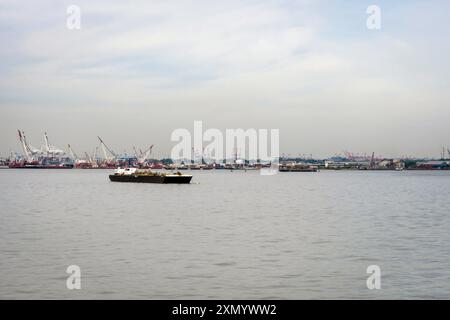 New York, Stati Uniti - 7 giugno 2019: Un peschereccio si muove attraverso le acque calme vicino a un vivace porto. Foto Stock