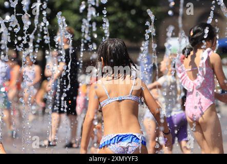 Londra, Regno Unito, 30 luglio 2024. I bambini si tengono al fresco nelle fontane di Granary Square, Kings Cross, a nord di Londra. Martedì doveva essere il giorno più caldo dell'anno con 32 gradi raggiunti, poiché un'ondata di caldo colpisce gran parte del Regno Unito. Non durerà a lungo, visto che i temporali sono previsti per la fine della settimana. Credito : Monica Wells/Alamy Live News Foto Stock