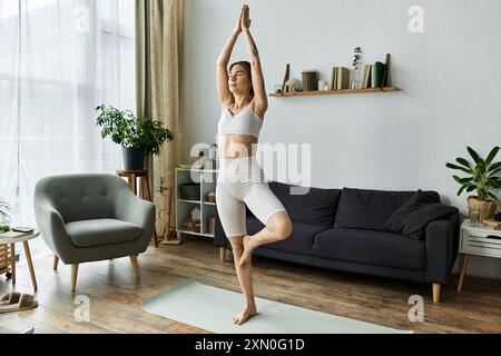 Una giovane donna con vitiligine pratica yoga in un appartamento moderno, trovando equilibrio e pace nel mezzo della quotidianità. Foto Stock