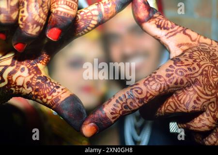 Coppia di nozze indù in posa, giovane coppia indiana sorridente con fiducia mentre fa un gesto quadrato con le mani Foto Stock