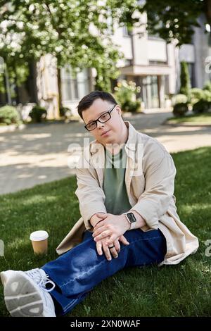 Un giovane con la sindrome di Down si siede sull'erba e sembra premuroso. Foto Stock