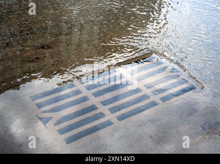 Gli scarichi meteorologici non sono in grado di rimuovere l'acqua dalla strada Foto Stock