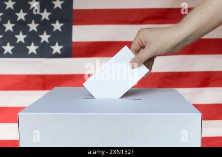 Primo piano del voto di un uomo in una urna con bandiera americana Foto Stock