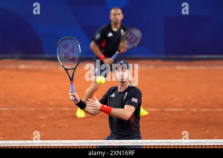 Andy Murray e Dan Evans in azione durante il secondo turno di doppio maschile contro il belga Joran Vliegen e Sander Gille (non nella foto) al Roland-Garros nella quarta giornata dei Giochi Olimpici di Parigi del 2024 in Francia. Data foto: Martedì 30 luglio 2024. Foto Stock