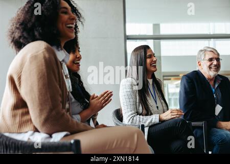 Gruppi diversi di uomini d'affari che fanno networking e ridono durante un evento aziendale, promuovendo connessioni e lavoro di squadra. Foto Stock