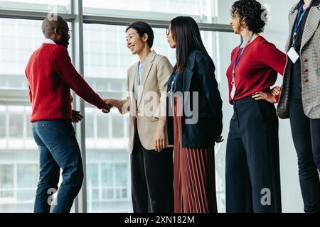 Presentazione di successo del team durante una riunione aziendale. Professionisti diversi che si impegnano in un'interazione positiva, promuovendo un ufficio collaborativo Foto Stock
