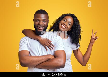 Coppia sorridente in posa su sfondo giallo Foto Stock
