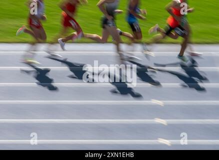 Corridori professionisti di gruppo nello stadio. Effetto di sfocatura del movimento. Poster a tema sportivo orizzontale, biglietti di auguri, intestazioni, sito Web e app Foto Stock