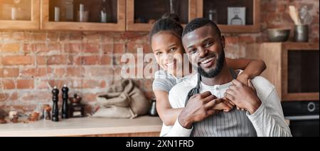 Grati bambina abbracciare il suo papà con amore in cucina Foto Stock