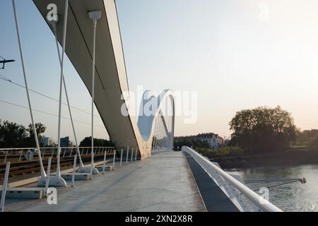 Kehl, Germania - 27 maggio 2023: Ponte Beatus Rhenanus visto dalla città tedesca di Kehl verso Strasburgo, in Francia, al tramonto, che mostra la silhouette del ponte contro un vivace cielo serale Foto Stock