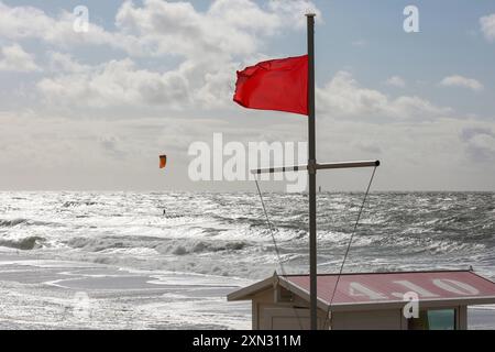 Rote Flagge am Strand von Westerland, Sylt DEU, Deutschland, Sylt, Westerland: DAS Bild zeigt eine rote Flagge, Die im Wind weht, auf einem Rettungsturm am Strand von Westerland auf Sylt. Die rote Flagge weist auf ein Badeverbot und Lebensgefahr beim Baden Hin. Im Hintergrund ist die stürmische Nordsee zu sehen. Ein Kitesurfer ist in der Ferne zu erkennen, der bei den hohen Wellen surft. Westerland Sylt Schleswig Holstein Deutschland *** bandiera rossa sulla spiaggia di Westerland, Sylt DEU, Germania, Sylt, Westerland l'immagine mostra una bandiera rossa che sventola nel vento su una torre di soccorso sulla spiaggia di Wes Foto Stock