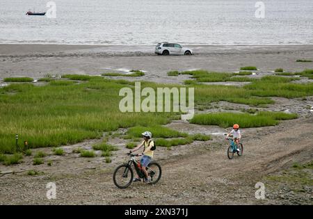 Ciclisti sulla spiaggia, vicino a dove un'auto è rimasta bloccata nella sabbia mobile, Lytham St Annes, Lancashire, Regno Unito, Europa Foto Stock