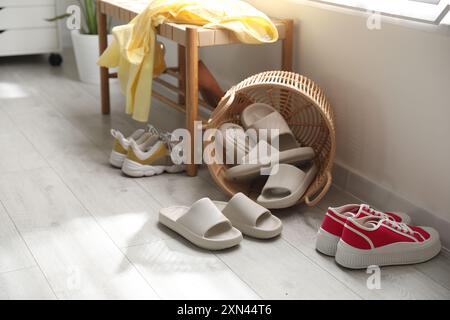 Cestino con pantofole per gli ospiti e scarpe da ginnastica all'ingresso di casa Foto Stock