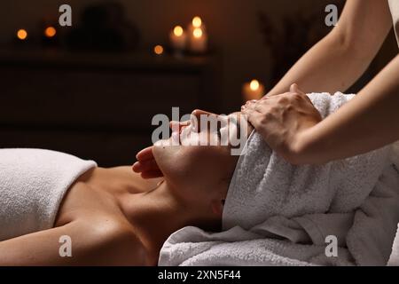 Donna attraente che si gode un massaggio facciale nel salone spa, primo piano Foto Stock