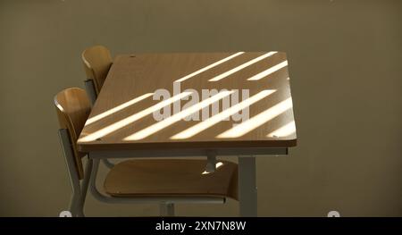 L'aula vuota presenta scrivanie e sedie in legno con luce solare che proietta linee d'ombra attraverso le tende alle finestre, creando un'atmosfera serena e tranquilla. Foto Stock