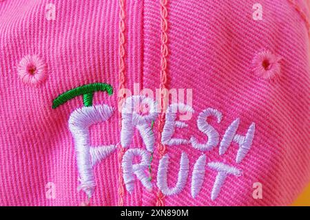 Primo piano di ricami di frutta fresca con un design giocoso su materiale rosa Foto Stock