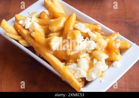 Poutine, un popolare cibo canadese a base di patatine fritte con sugo di carne e curdi al formaggio Foto Stock