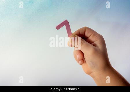 Numero 7 sette di legno nella mano di un bambino Foto Stock