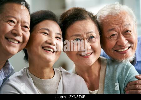 persone asiatiche senior felici due coppie sedute sul divano di famiglia per scattare una foto di gruppo Foto Stock