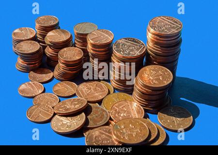 Monete britanniche di basso valore su sfondo blu uniforme con monete da 1p, 2p incluse. Per molti anni ci sono state speculazioni su quando potrebbero essere disco Foto Stock